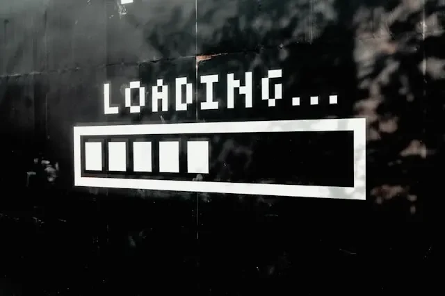 Icône de chargement « Loading… » peinte sur un mur sombre