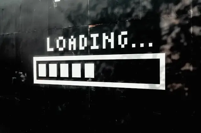 Icône de chargement « Loading… » peinte sur un mur sombre