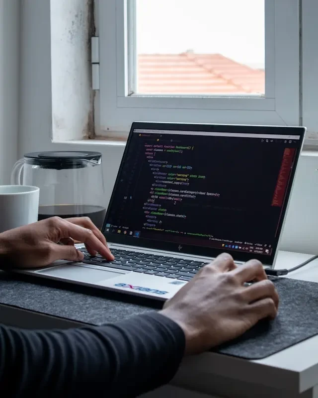 Développeur codant sur un ordinateur portable affichant du code coloré